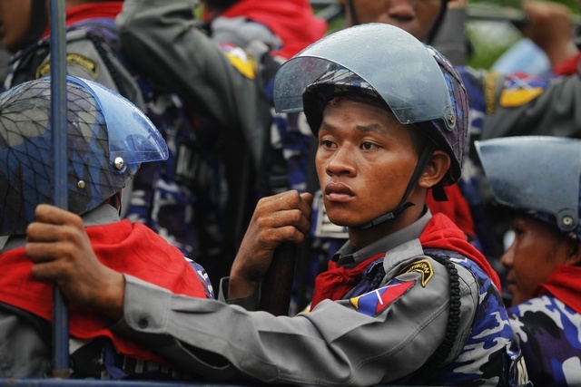 Policemen arrive in their vehicle during the rioting in Sittwe on 10 June 2012. (Reuters)